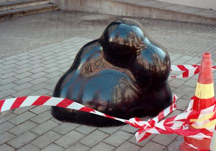 Chiaki Kobinata: Musta graniittiveistos (2014). Kuva: Aura Saarikoski Kuvassa musta pyöreänmuotoinen abstrakti graniittiveistos, jonka edessä eristysnauha.