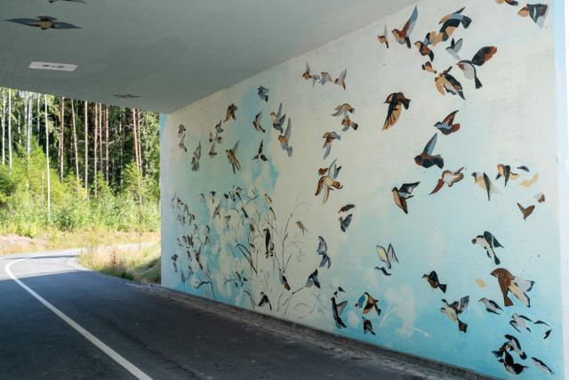 Lammenkallion alikulkutunnelia koristaa vaaleansinisävyinen muraali, jossa lintuparvi lentää ikään kuin tunnelin sisään. 