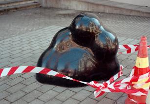Chiaki Kobinata: Musta graniittiveistos (2014). Kuva: Aura Saarikoski Kuvassa musta pyöreänmuotoinen abstrakti graniittiveistos, jonka edessä eristysnauha.